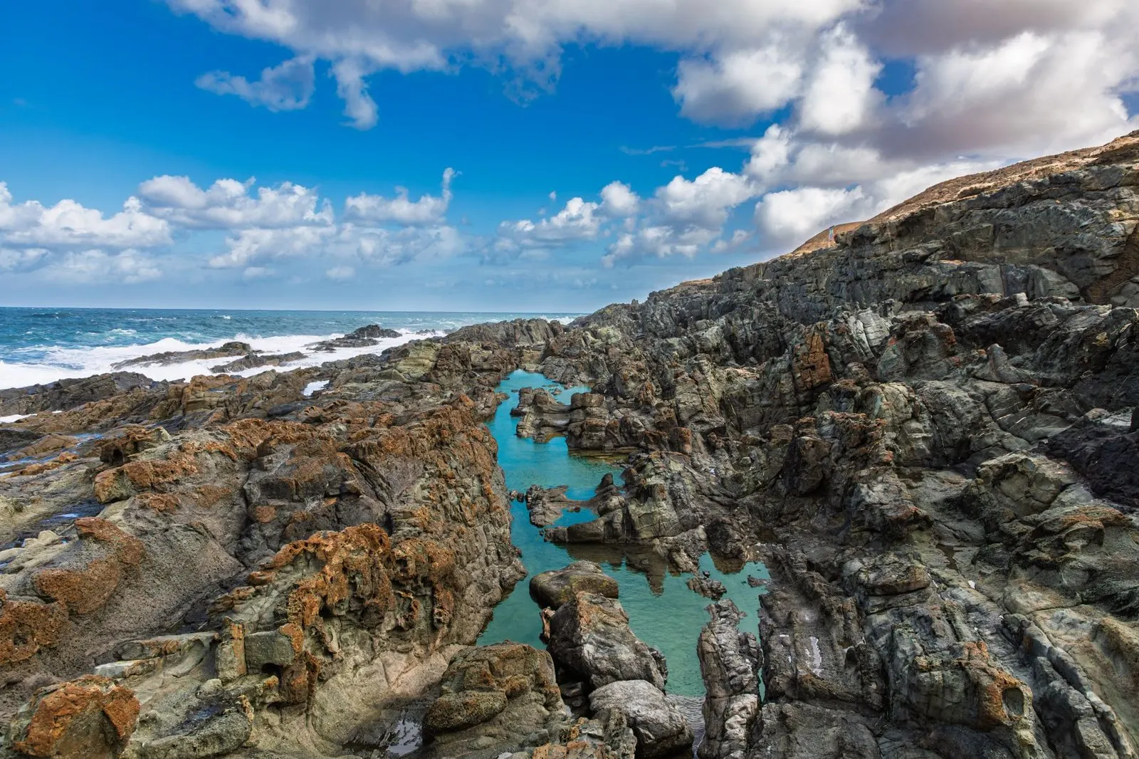 Turquoise ponds among volcanic rocks on the Canarian coast